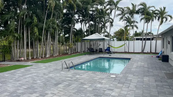 Completed pool patio with pavers and turf