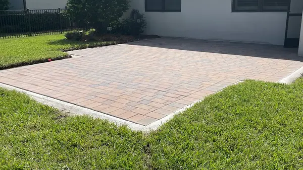 Completed pool patio with pavers and turf
